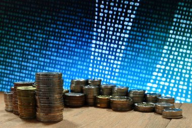 Dijital Ekonomi. Sikke yığını mavi ikili dijital sayılar arka plan ile. İş, finans ve kavram kaydetme.