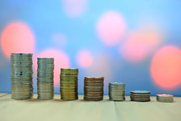 artan grafik sikkeleri yaptı. Para bir ahşap tahta üzerinde kule için üst üste. Yumuşak ışık kırmızı bokeh arka plan. İş tasarruf finansal kavramlar