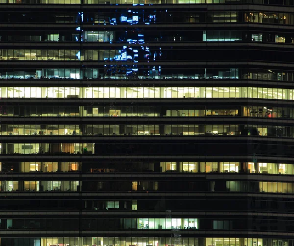 Ofis Binası geceleri. Geç gece iş yerinde. Cam perde duvar ofis binası