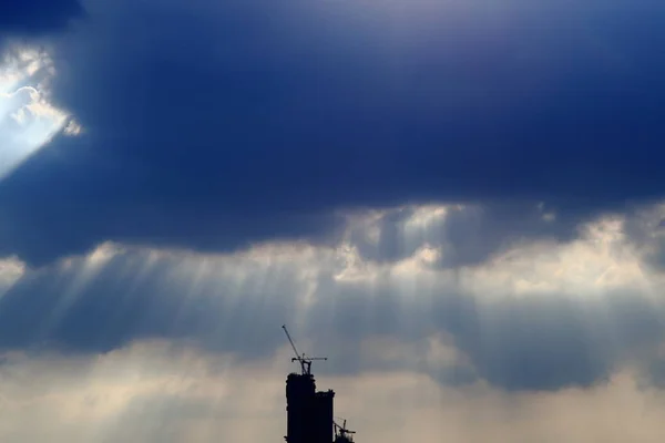 Silhouette Cityscape Powerful Sun Light Beaming Dark Cloudy Sky — Stock Photo, Image