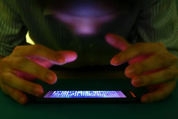 Smartphone bağımlılığı sosyal medya tuzak. Bir karanlık odada Smartphone basarak beyaz genç bir adam. uzun pozlama atış smartphone üzerinde duruldu. Modern toplumsal sorun kavramı.