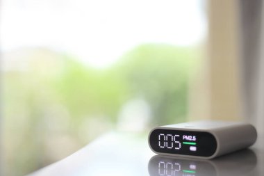 Başbakan 2.5 toz dedektörü ve yeşil bokeh arkaplan. Partikül madde parçacıkları toz sensörü temiz hava algılıyor. Sağlıklı temiz hava ve az miktarda görünmez zararlı kirlilik.