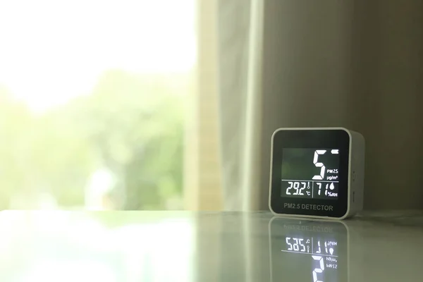 air quality sensor placing on a table indoor. sensor found small amount of air pollution of PM 2.5 the poisonous harmful particulate matter invisible dust from open field fire. man-made disasters.
