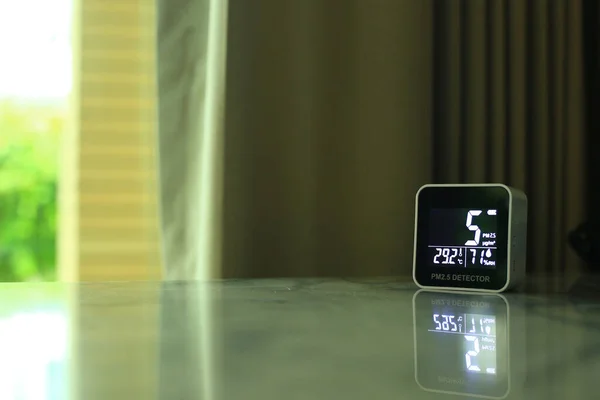 air quality sensor placing on a table indoor. sensor found small amount of air pollution of PM 2.5 the poisonous harmful particulate matter invisible dust from open field fire. man-made disasters.