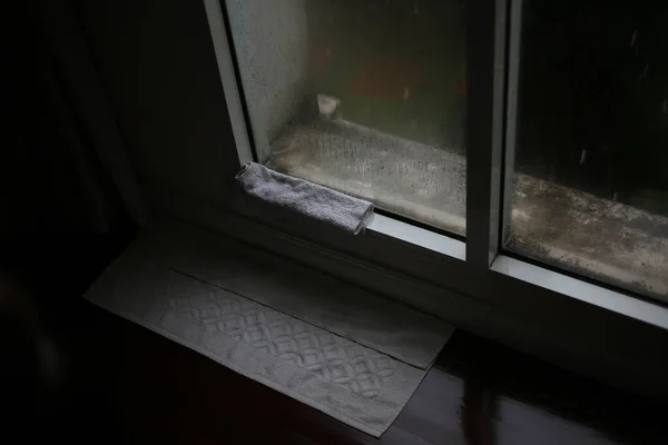 Bina odasına su sızıyor çünkü pencere silikon kapağı sızdırıyor. Cam pencere köşesindeki su sızıntısını gidermek için bez parçaları kullandık. mimari iç ve ev sorunları.