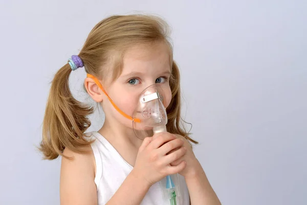 Niño, niño (niña pequeña) con inhalador (nebulizador) hace el procedimiento .. — Foto de Stock