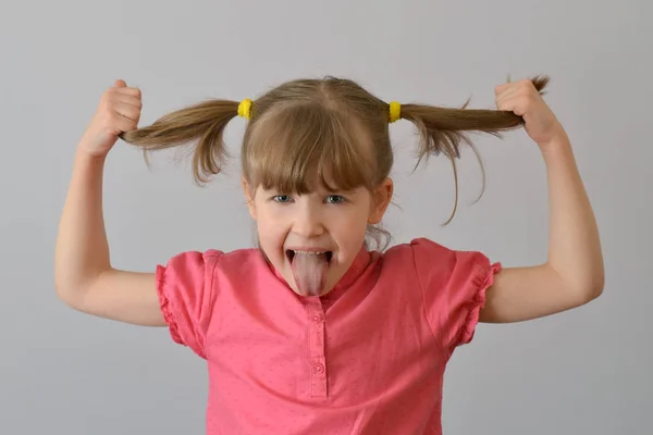 çocuk, çocuk, komik bir yapılar ve gösterir grimasy dil. 