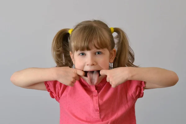 çocuk, çocuk, komik bir yapılar ve gösterir grimasy dil. 