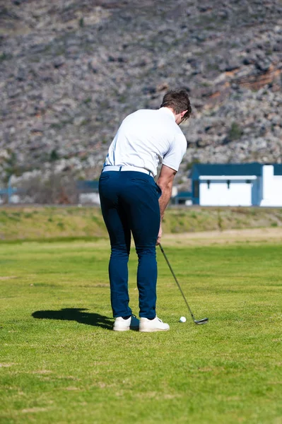 yeşil üzerine bir çip şans oynarken golfçü