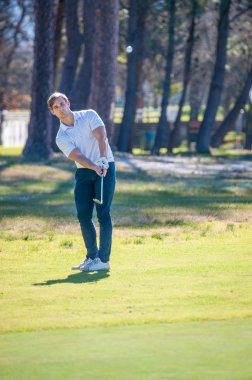 yeşil üzerine bir çip şans oynarken golfçü