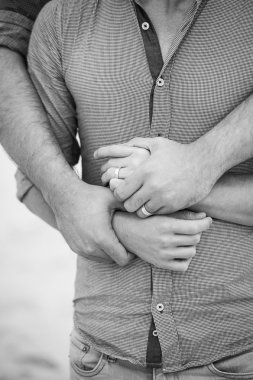 Eşcinsel erkekler bir kumsalda kucaklayan