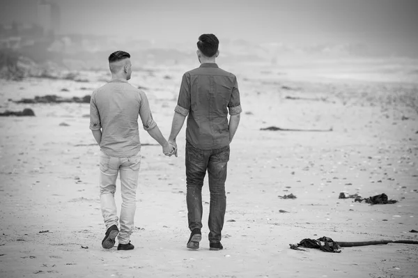 Gay par promenader innehav händer — Stockfoto