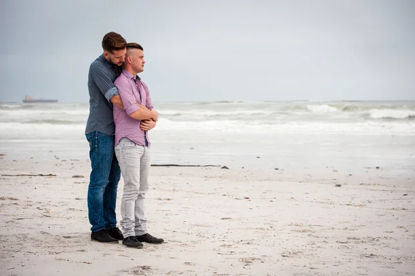 Gay muži všeobjímající na pláži — Stock fotografie