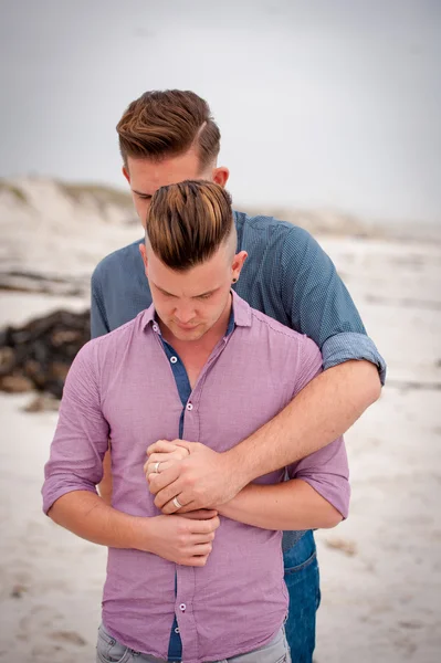 Gay muži všeobjímající na pláži — Stock fotografie