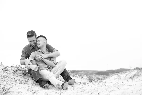 Gay muži všeobjímající na pláži — Stock fotografie