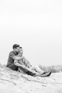 Eşcinsel erkekler bir kumsalda kucaklayan