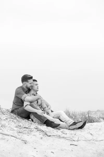 Gay män embracing på en strand — Stockfoto
