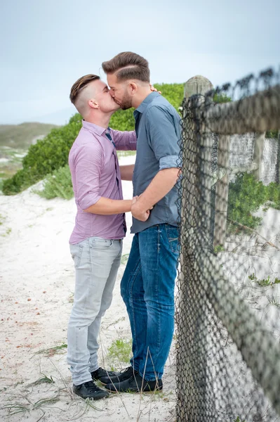 Gay muži všeobjímající na plot — Stock fotografie