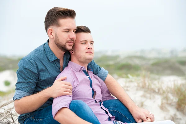 Gay muži všeobjímající na pláži — Stock fotografie