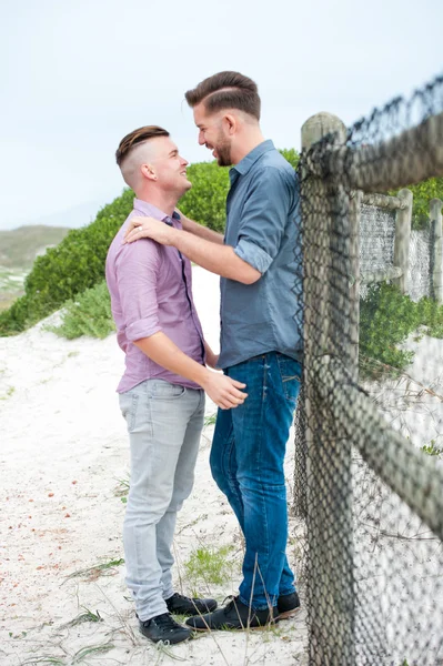 Gay muži všeobjímající na plot — Stock fotografie
