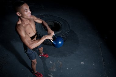Bir dövme ile erkek crossfit sporcu bir kettlebell salıncaklar