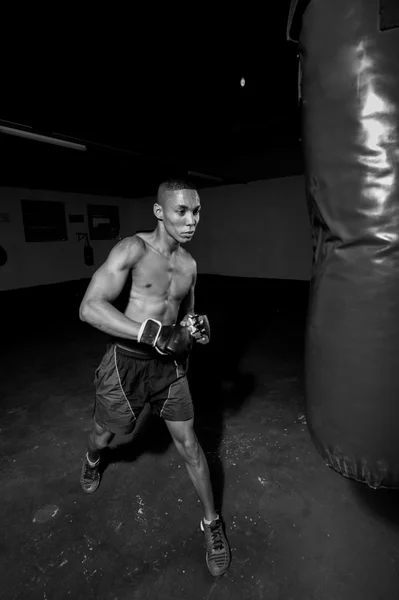 Mixed race kickboxer with punchbag — Stock Photo, Image