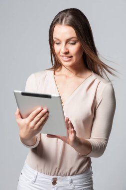 Gülümseyen bir tablet tutan genç iş kadın portresi