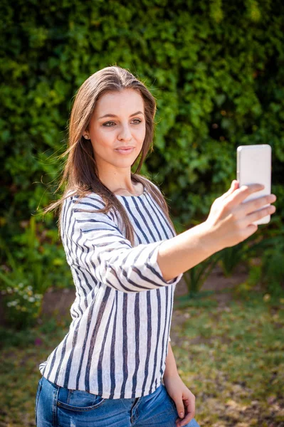 Kvinna på en smart telefon utanför — Stockfoto