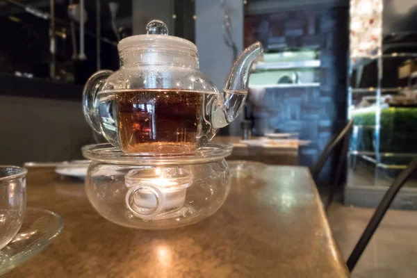 Panela de chá de vidro em uma mesa em um café — Fotografia de Stock