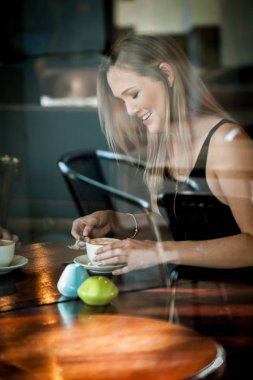 Bir kafede kahve içme penceresinde kız oturdu