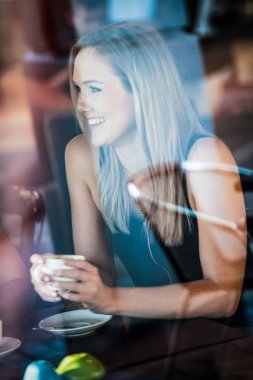 Bir kafede kahve içme penceresinde kız oturdu