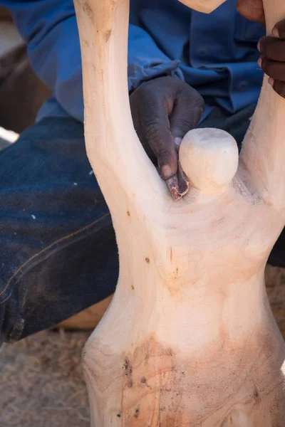 sanding a wooden sculpture