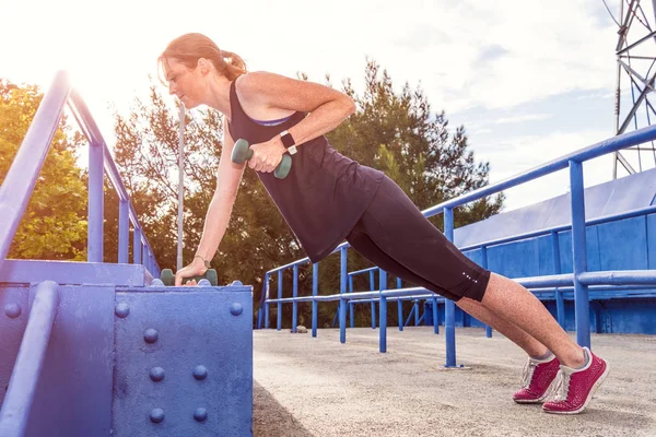 Mujer haciendo ejercicio usando mancuernas —  Fotos de Stock