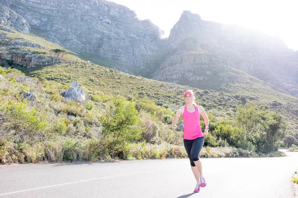 Female runner with mountain background — Stock Photo, Image