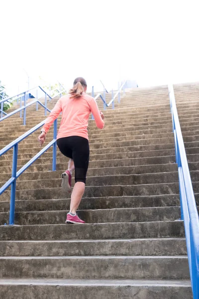 Femelle athlétique montant un escalier — Photo