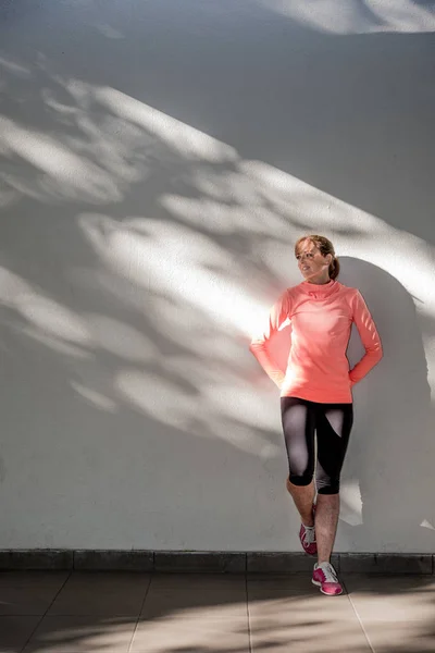 Atleta feminina que se estende na rua — Fotografia de Stock