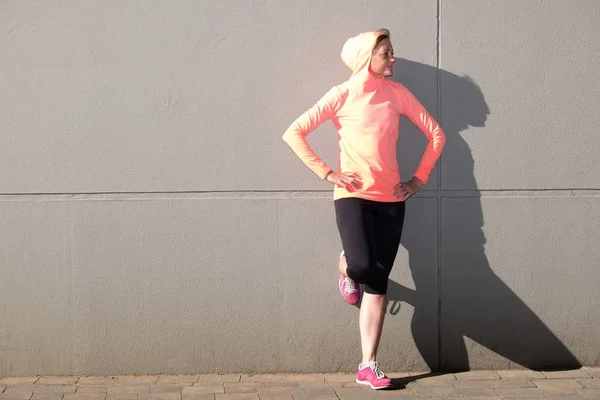 Female athlete stretching on the street — Stock Photo, Image