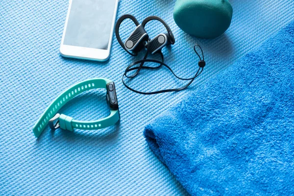 Aparatos de fitness y electrónica en una esterilla de yoga azul — Foto de Stock