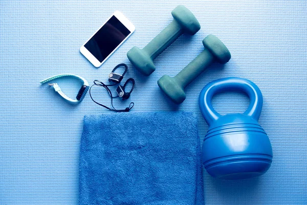 Aparatos de fitness y electrónica en una esterilla de yoga azul — Foto de Stock