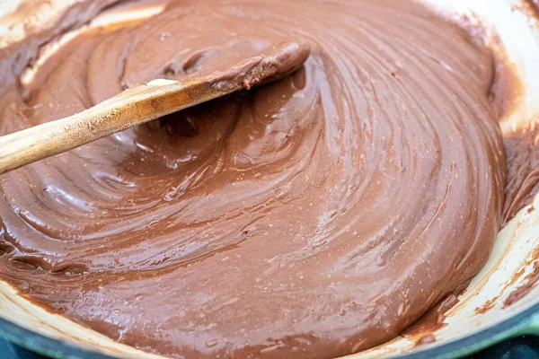 melted chocolate, butter and condensed milk in a pan as part of a process to make home made fudge