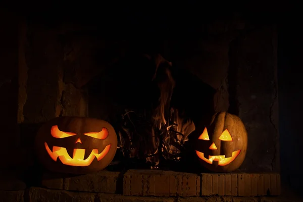Två Halloweenpumpor på spisen med eld i mörkret med y — Stockfoto