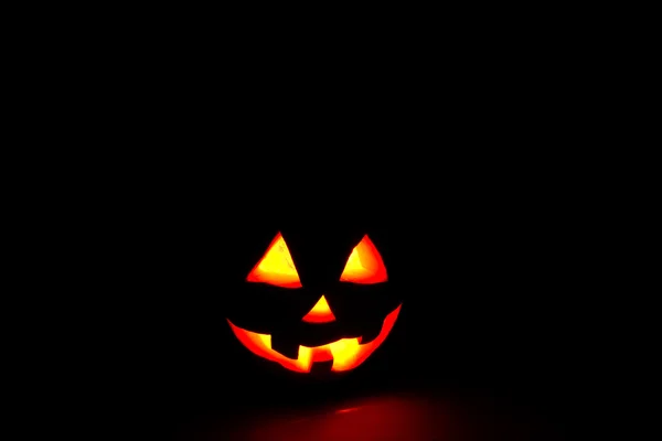 Funny calabaza de Halloween aislado sobre un fondo negro resplandor de —  Fotos de Stock