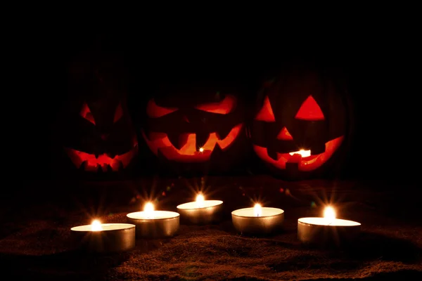 Halloween tök életlen három töklámpás a sötétben — Stock Fotó