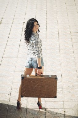 Eski bir bavul, sarılı olan yalnız esmer kadın