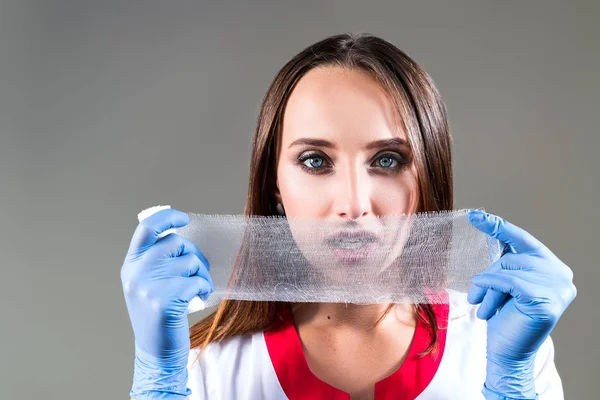 Kvinna läkare, sjuksköterska, närbild, håller ett plåster i ansiktet, med utrymme för text — Stockfoto