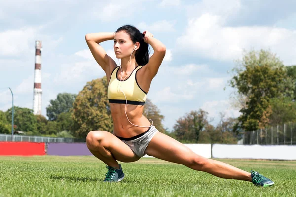 Chica delgada con una figura deportiva en pantalones cortos, haciendo ejercicio —  Fotos de Stock
