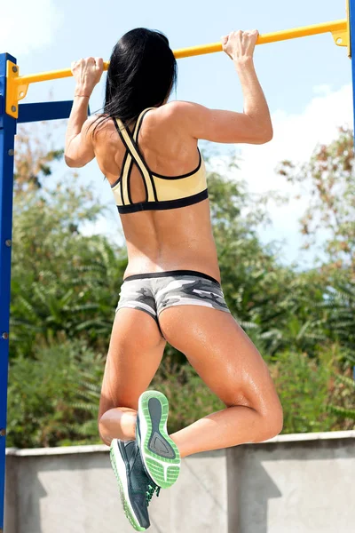 Chica delgada con una figura deportiva en pantalones cortos, haciendo ejercicios — Foto de Stock