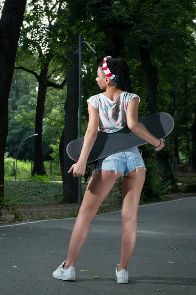 세련 된 갈색 머리 소녀 안경 반바지, 스케이트 보드, 보유 하 고 있는 — 스톡 사진