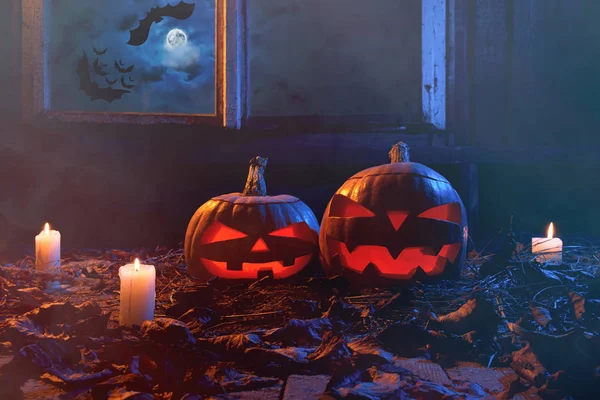 Halloween - calabazas y velas en una casa de madera abandonada en —  Fotos de Stock