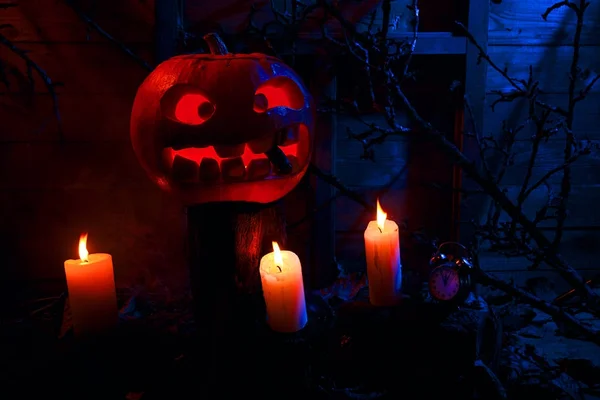 Halloween - abóbora, velas e um relógio em folhas e logs com — Fotografia de Stock